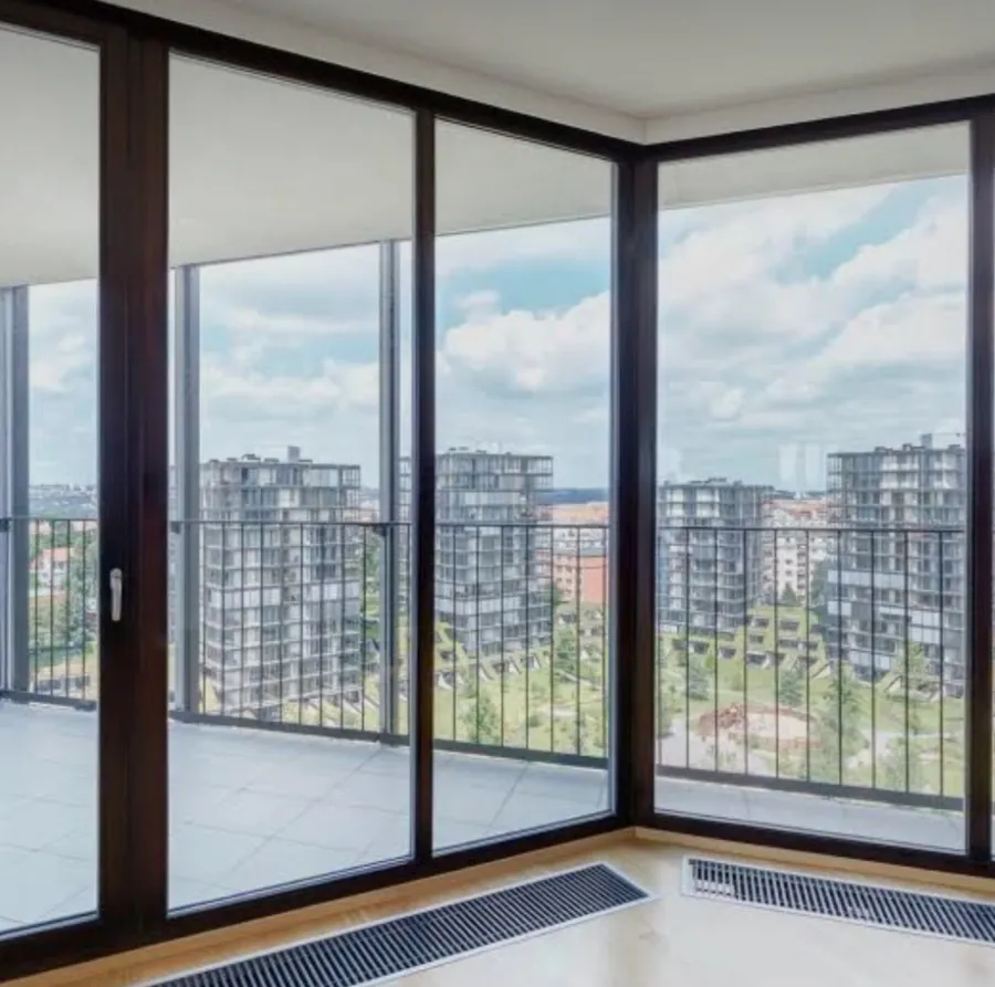 Staklene stijene od poda do stropa u tamnim aluminijskim profilima, kutni spoj s pogledom na balkon